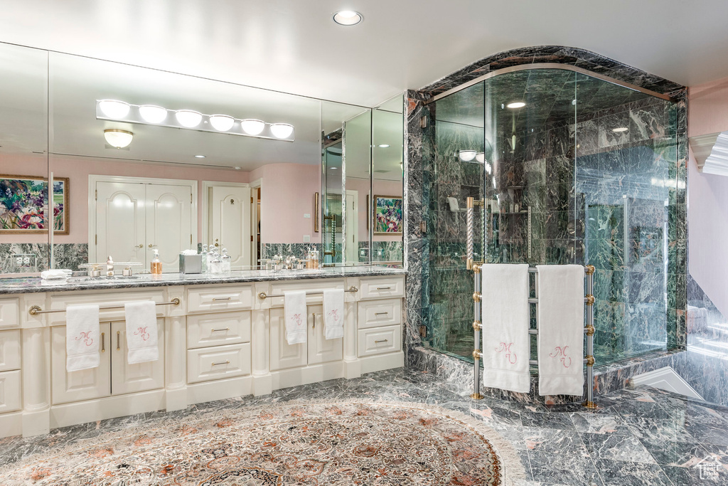 Full bath with vanity, a marble finish shower, and recessed lighting