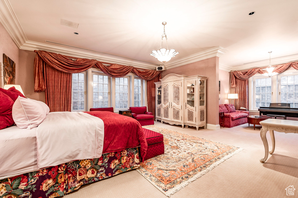 Bedroom with multiple windows, crown molding, carpet flooring, and a chandelier