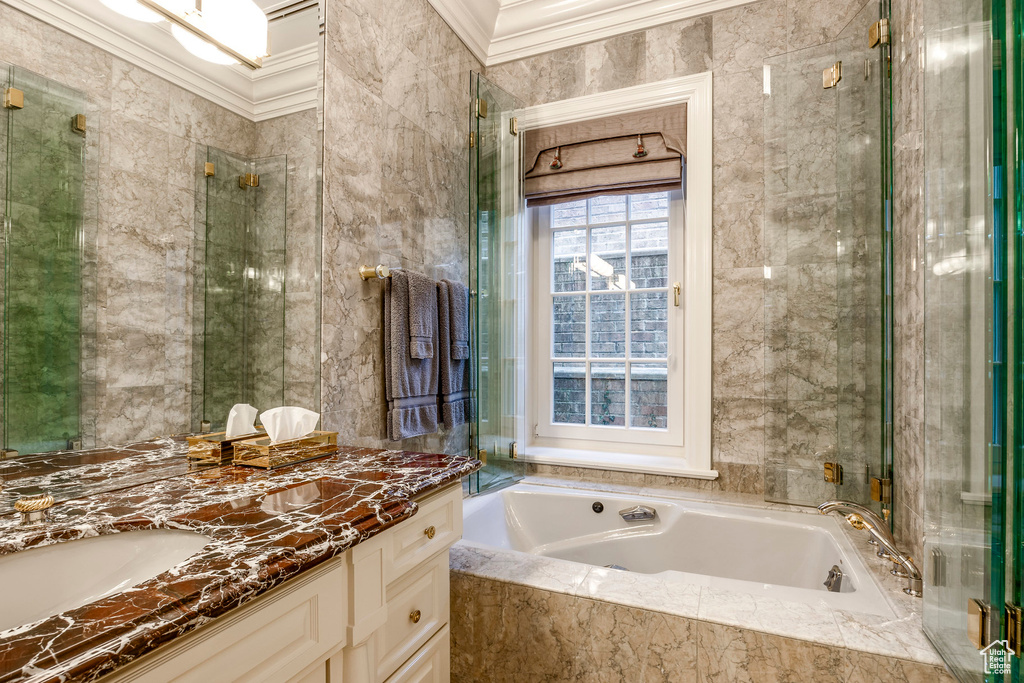 Bathroom featuring vanity, crown molding, and a bath
