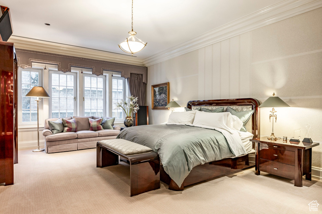 Carpeted bedroom featuring crown molding and baseboards