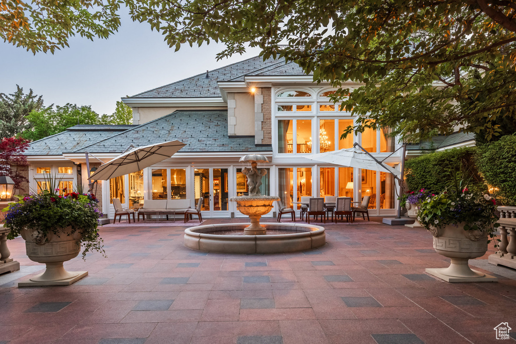 Rear view of property featuring a high end roof and a patio area