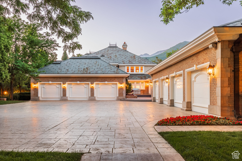 View of front of property with community garages, a mountain view, and brick siding