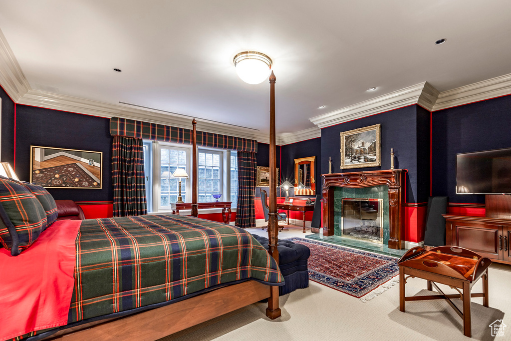 Carpeted bedroom featuring crown molding and a fireplace