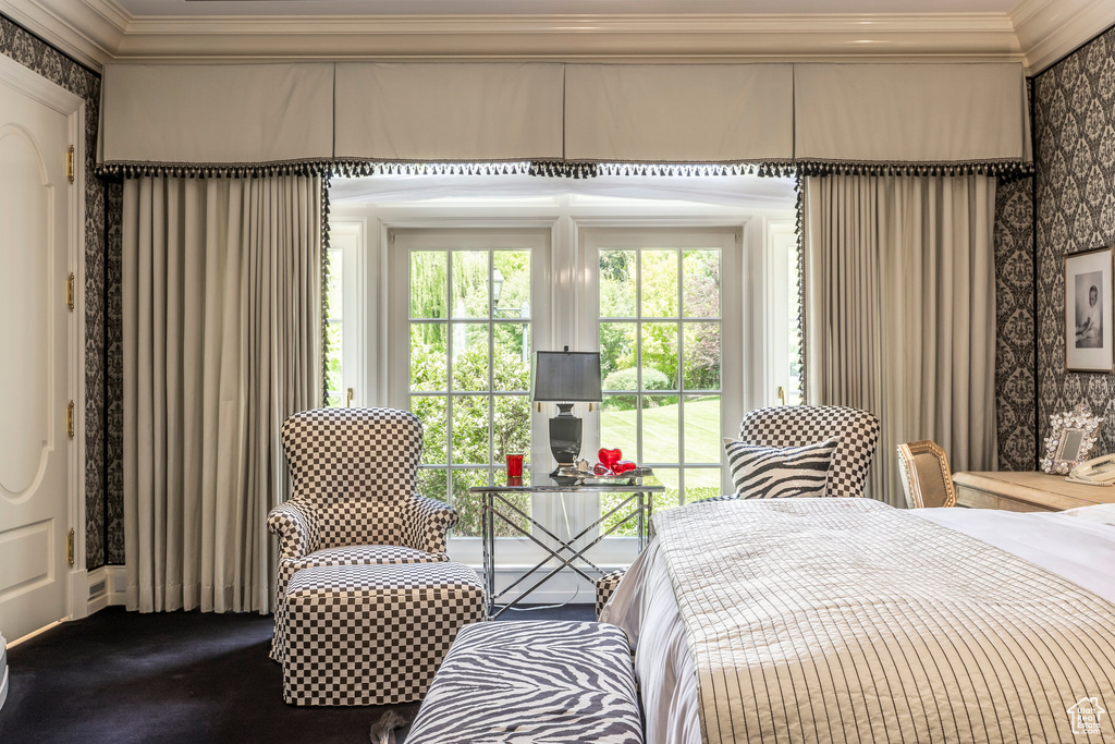 Bedroom featuring ornamental molding, wallpapered walls, and dark colored carpet