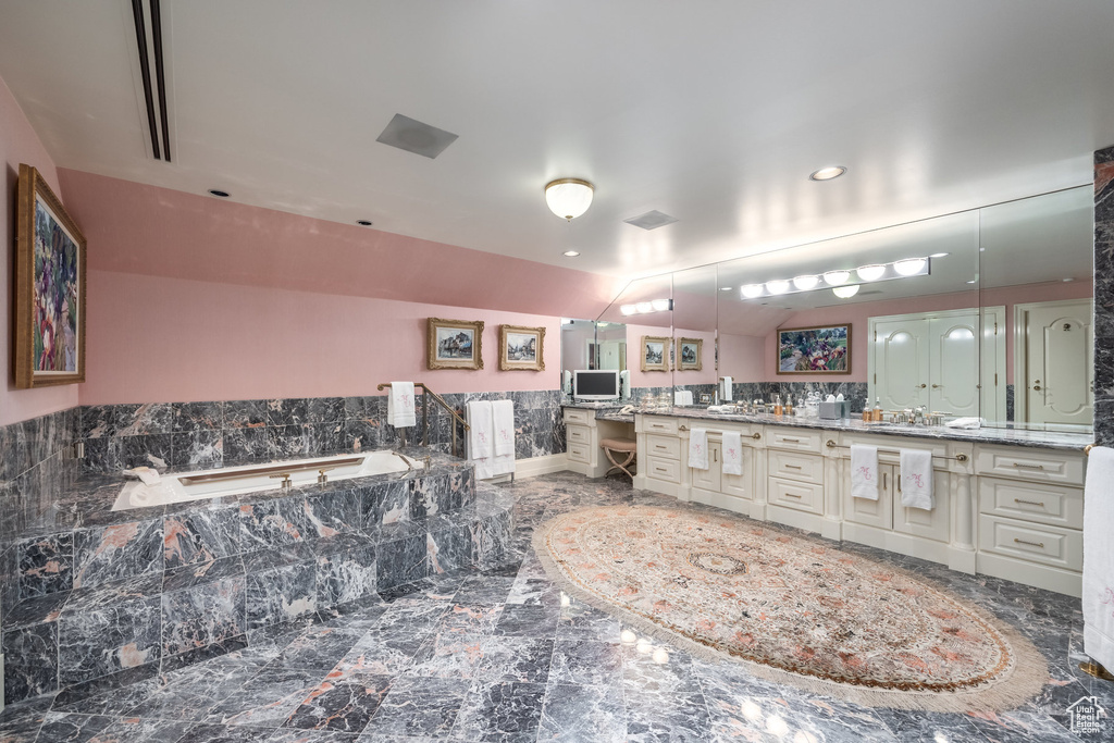 Full bath featuring vanity, a bath, marble finish floors, and recessed lighting