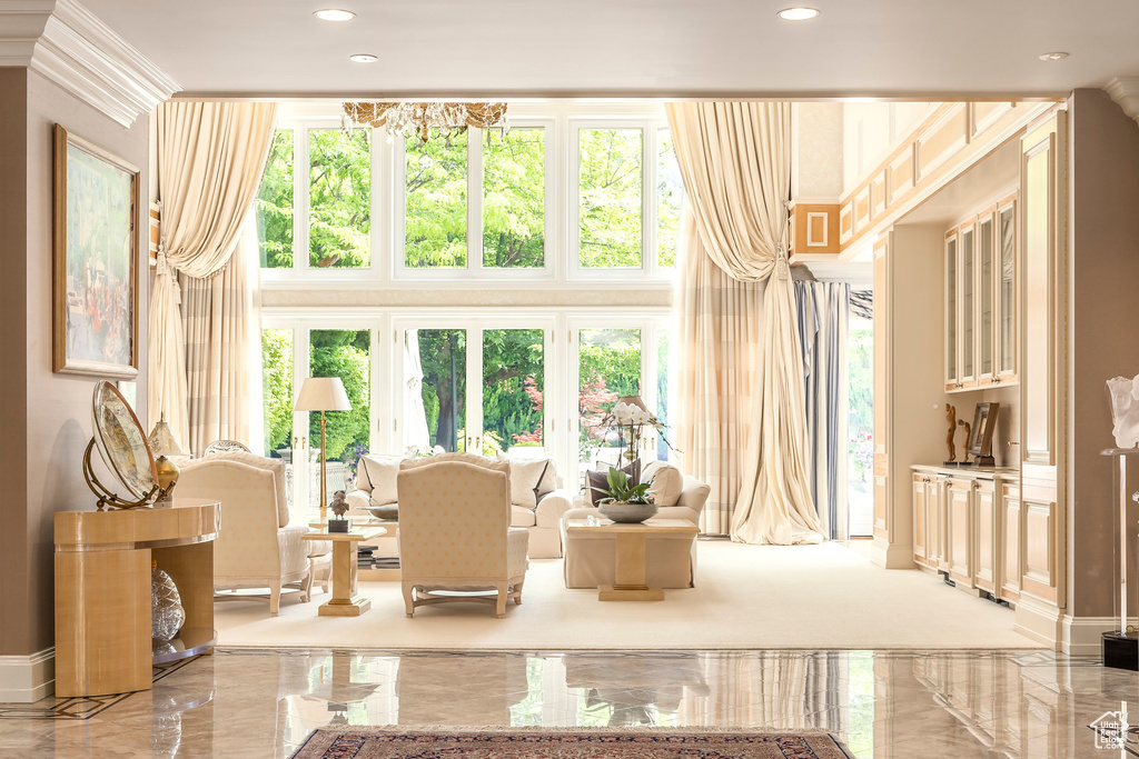 Living area with marble tiled flooring, a towering ceiling, plenty of natural light, and recessed lighting