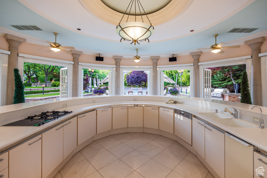 Kitchen featuring gas stovetop, a ceiling fan, dishwashing machine, and decorative columns
