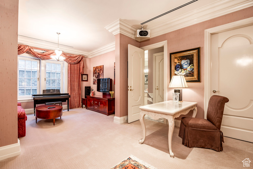 Sitting room with a chandelier, light colored carpet, and ornamental molding