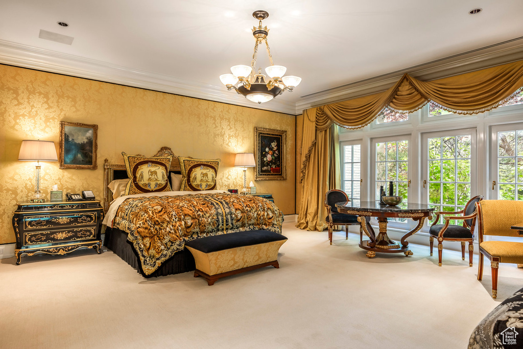 Carpeted bedroom with access to outside, ornamental molding, and a chandelier