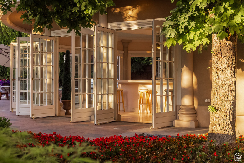 View of exterior entry featuring french doors and stucco siding