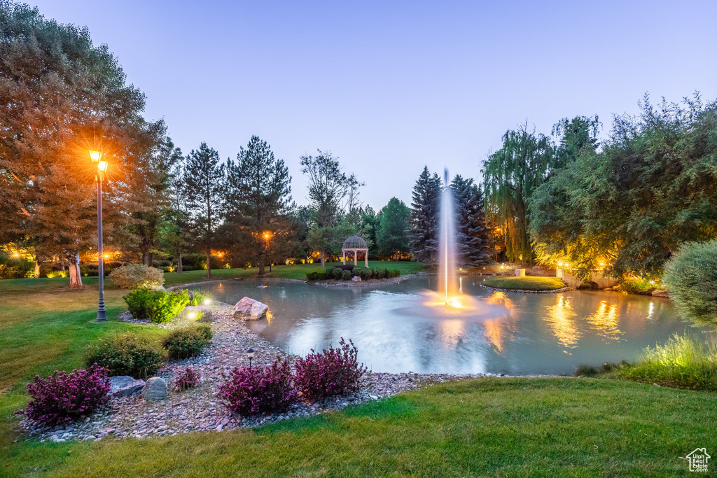Surrounding community featuring a lawn and a water view