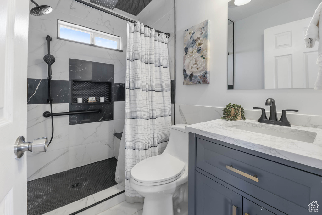 Full bath with marble finish floors, vanity, and a shower with shower curtain