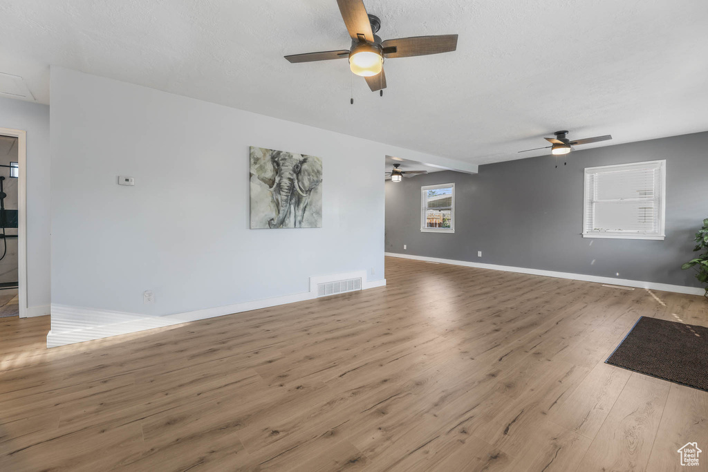Unfurnished living room with a ceiling fan and wood finished floors