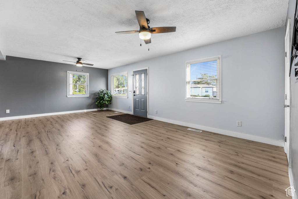 Foyer entrance featuring a ceiling fan, wood finished floors, and a textured ceiling