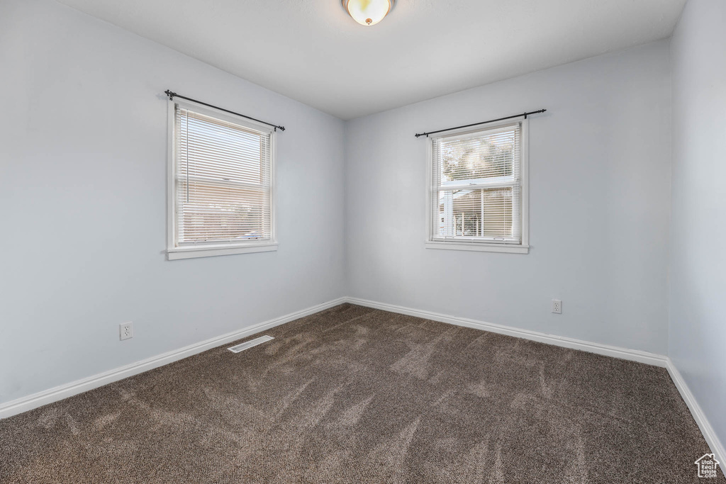 Spare room featuring carpet floors and baseboards