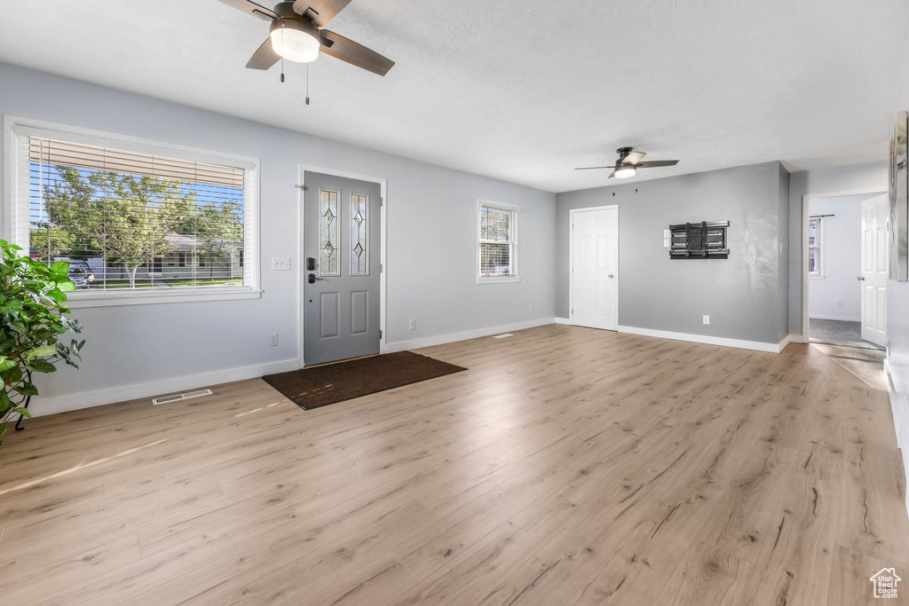 Entrance foyer with ceiling fan and light wood-style flooring