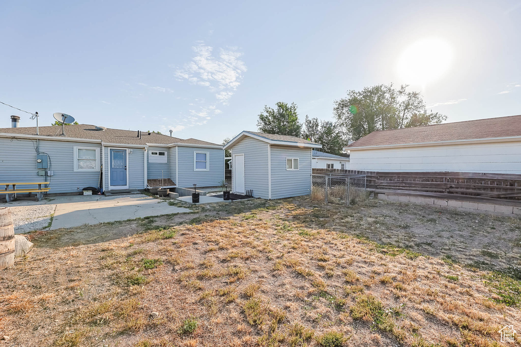 Back of property with a patio area and an outdoor structure