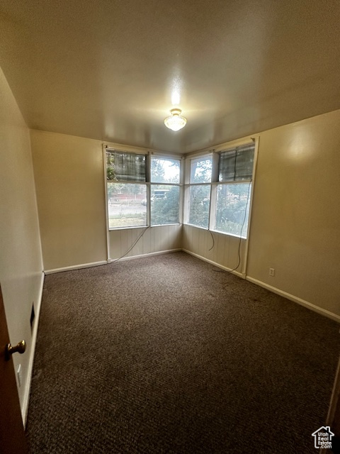 Carpeted empty room with baseboards