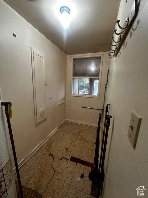 Laundry area with baseboards and water heater