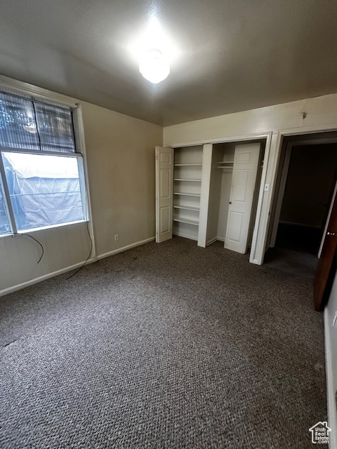 Unfurnished bedroom with carpet flooring and a closet