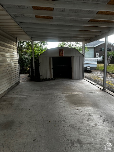 View of car parking featuring a storage shed