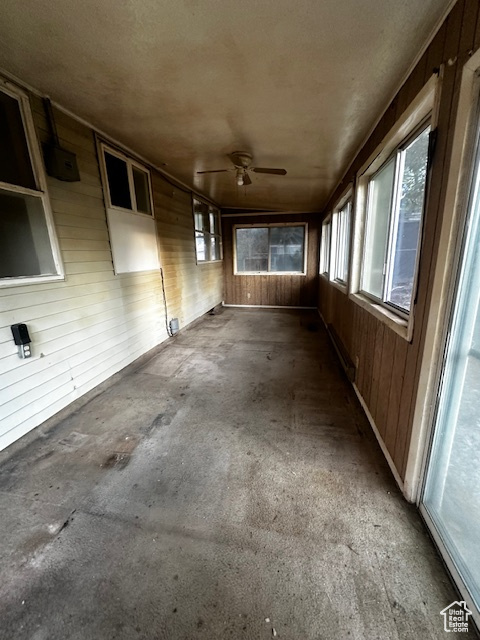 Unfurnished sunroom featuring ceiling fan