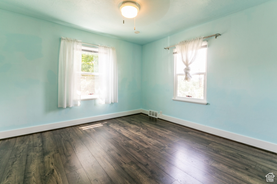 Empty room with dark wood-style flooring and baseboards