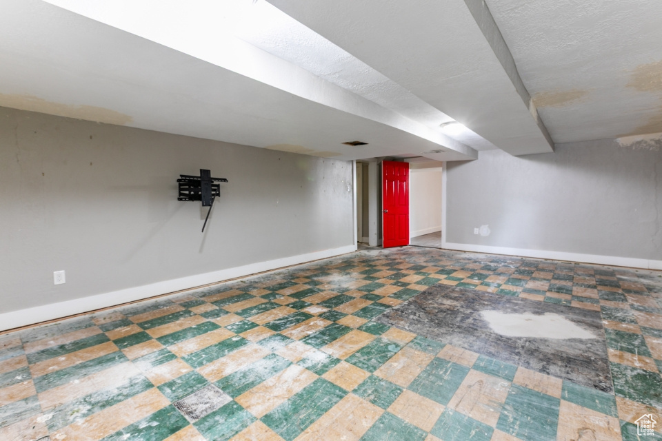 Finished below grade area featuring baseboards and tile patterned floors