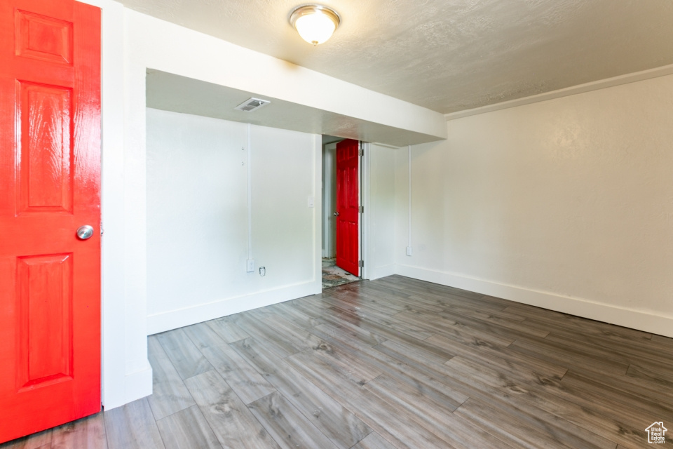 Unfurnished room featuring wood finished floors and a textured ceiling