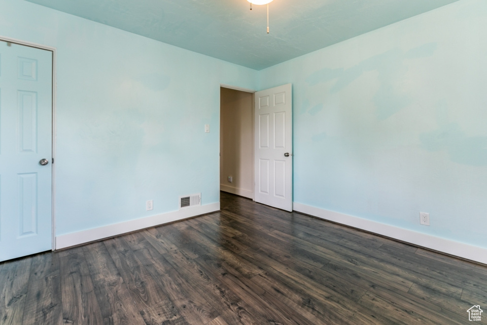 Spare room featuring baseboards and dark wood finished floors