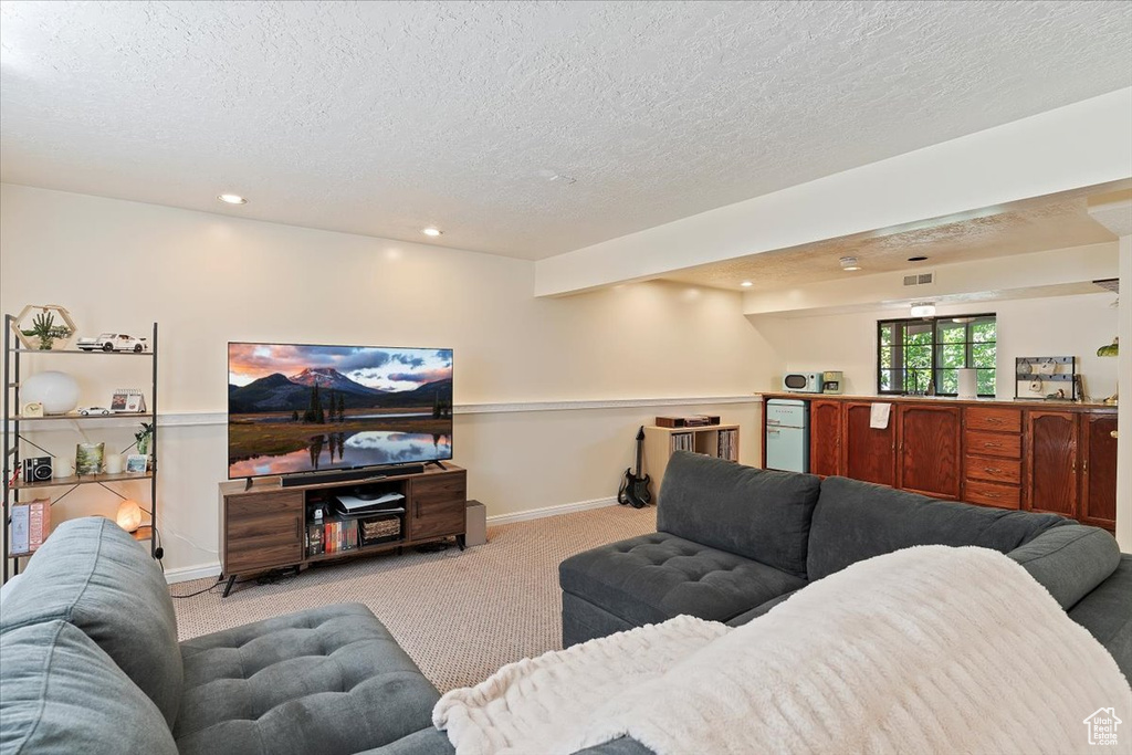 Carpeted living area with a textured ceiling and recessed lighting