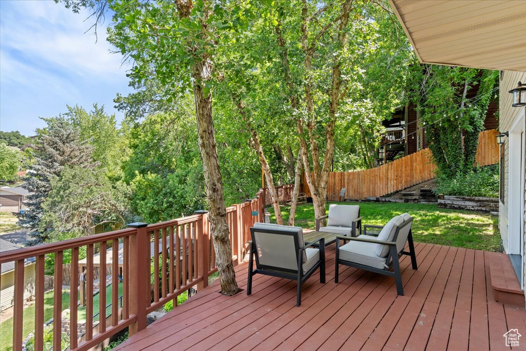Wooden deck featuring a fenced backyard and outdoor lounge area