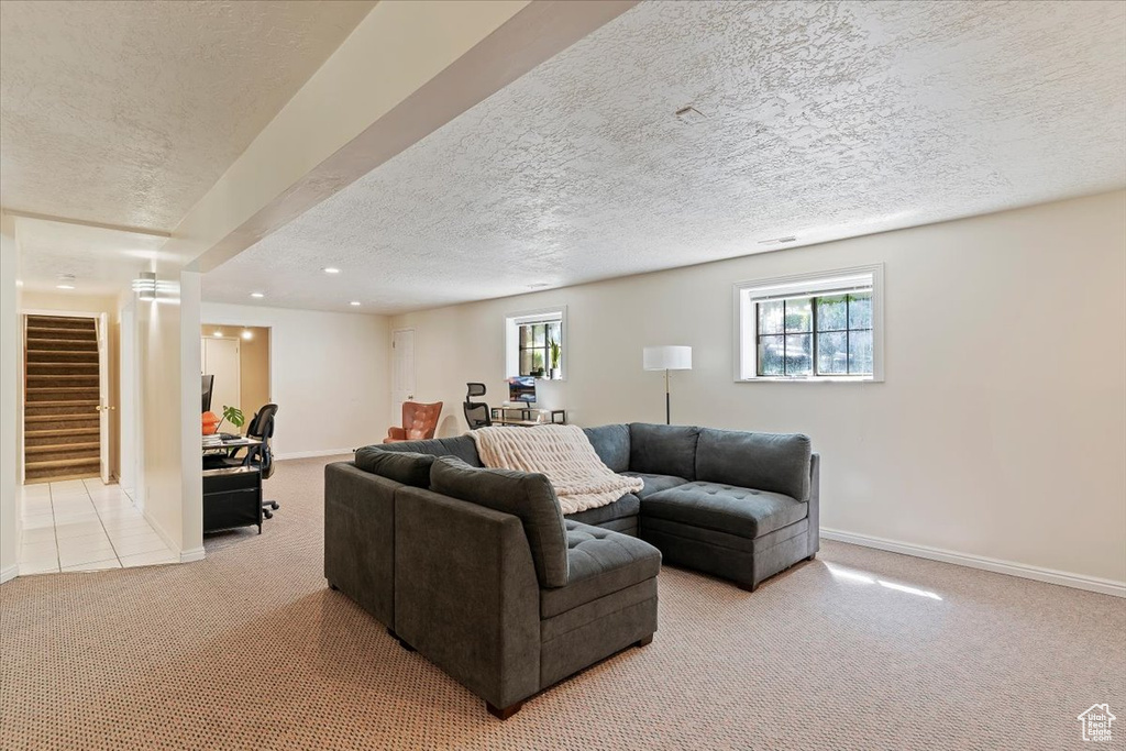 Living room featuring light colored carpet, a textured ceiling, stairs, plenty of natural light, and recessed lighting