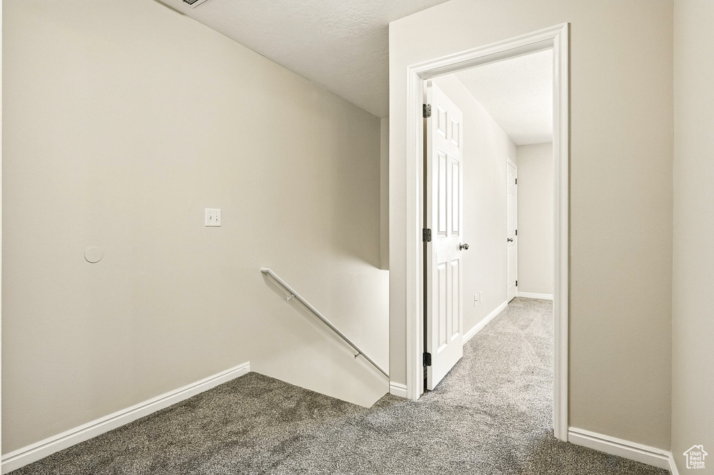 Hall featuring an upstairs landing and carpet flooring