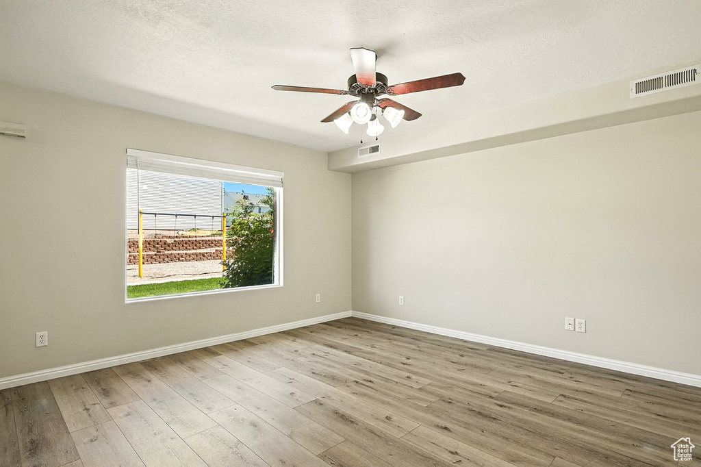 Empty room with wood finished floors and a ceiling fan