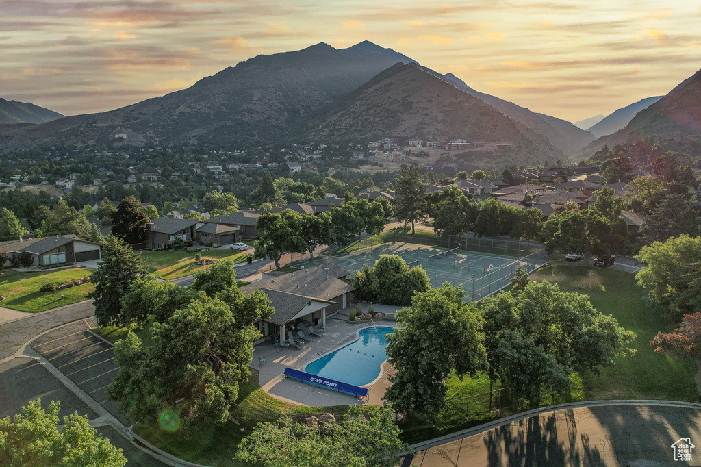 Aerial view at dusk of view of pool, a mountain view, and a residential view