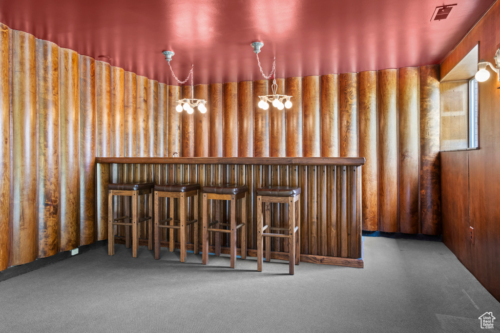 Bar area featuring carpet flooring and a chandelier
