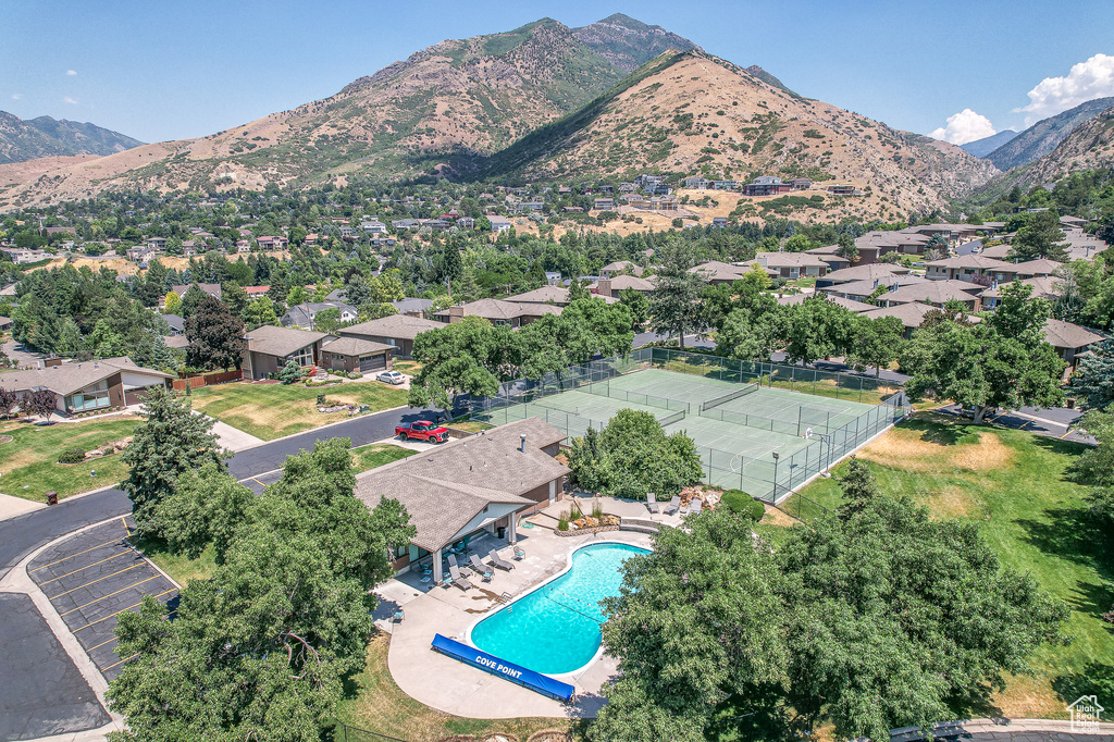 Aerial perspective of suburban area with mountains and a pool