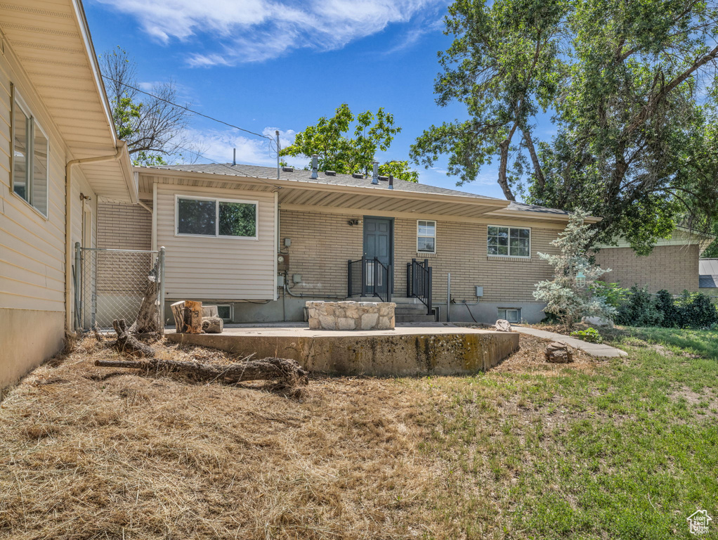 Rear view of house with brick siding and a yard