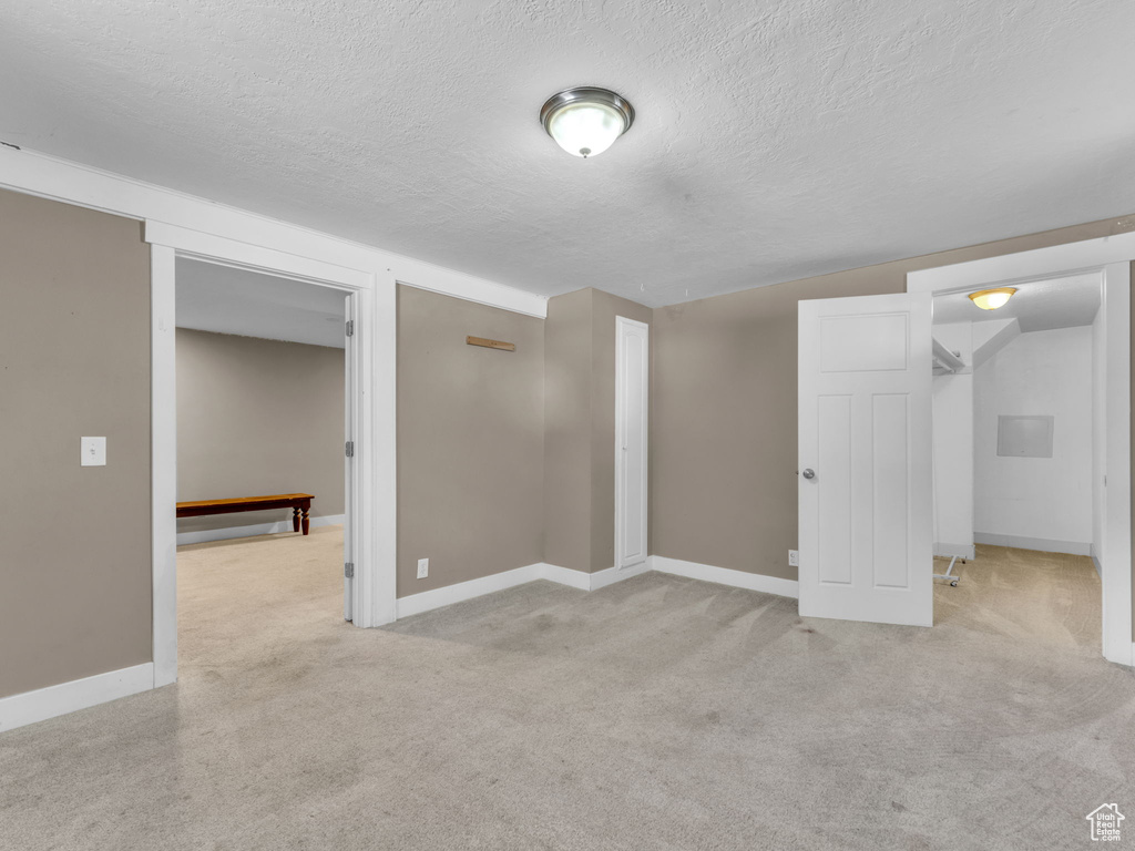 Carpeted empty room with a textured ceiling