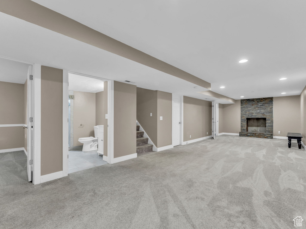 Finished below grade area with carpet, a fireplace, recessed lighting, and stairway