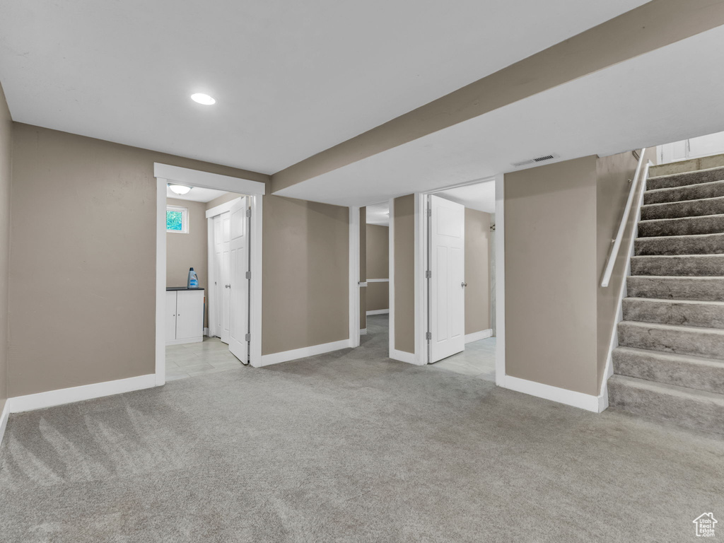 Below grade area featuring carpet floors, stairway, and recessed lighting