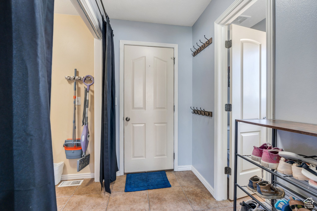 Foyer entrance featuring light tile patterned flooring and baseboards