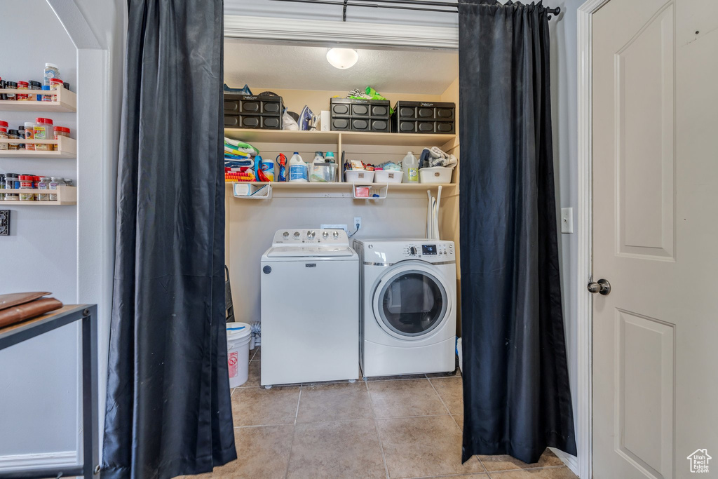 Laundry room with washer and dryer and tile patterned floors