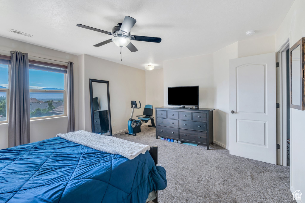 Carpeted bedroom with ceiling fan and baseboards