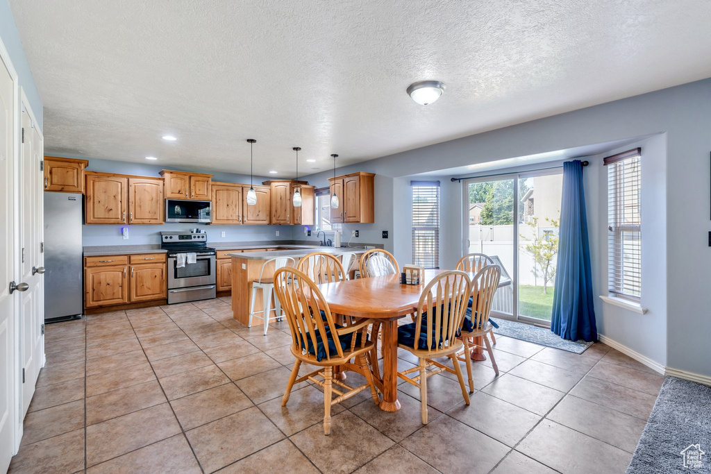Dining space featuring a textured ceiling, light tile patterned floors, and recessed lighting