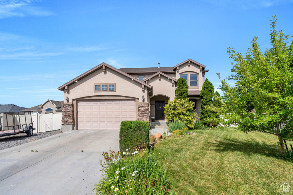 View of front of property with stucco siding, concrete driveway, a gate, a garage, and stone siding