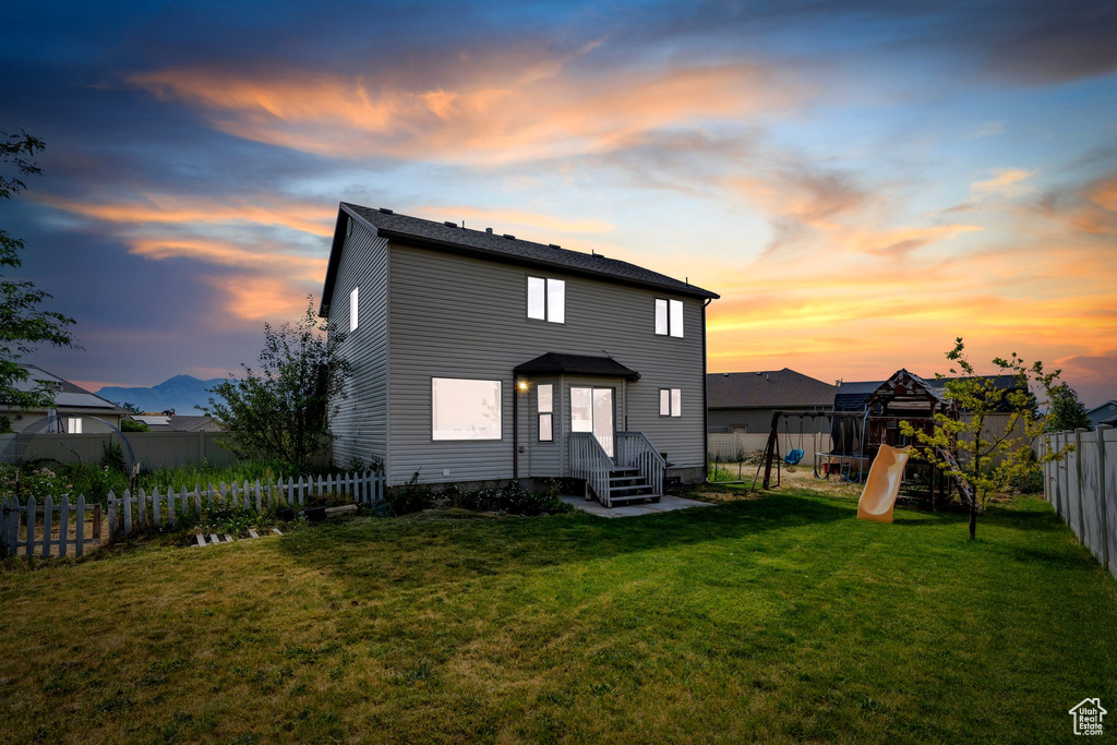 Rear view of property with a playground and a fenced backyard