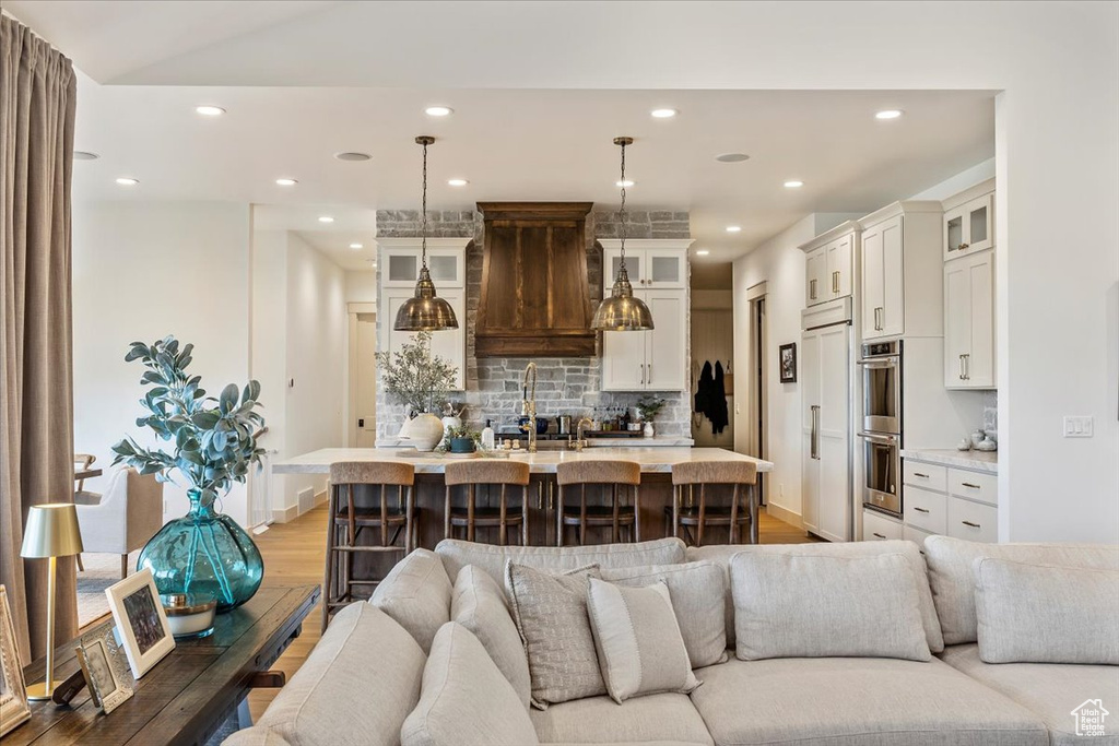 Living room with light wood-style floors and recessed lighting