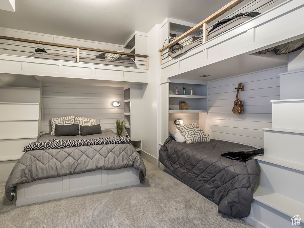 Bedroom with carpet flooring and wood walls